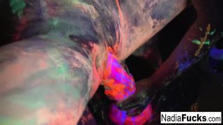 Black-light babes Nadia and Ophelia suck off a colorful cock